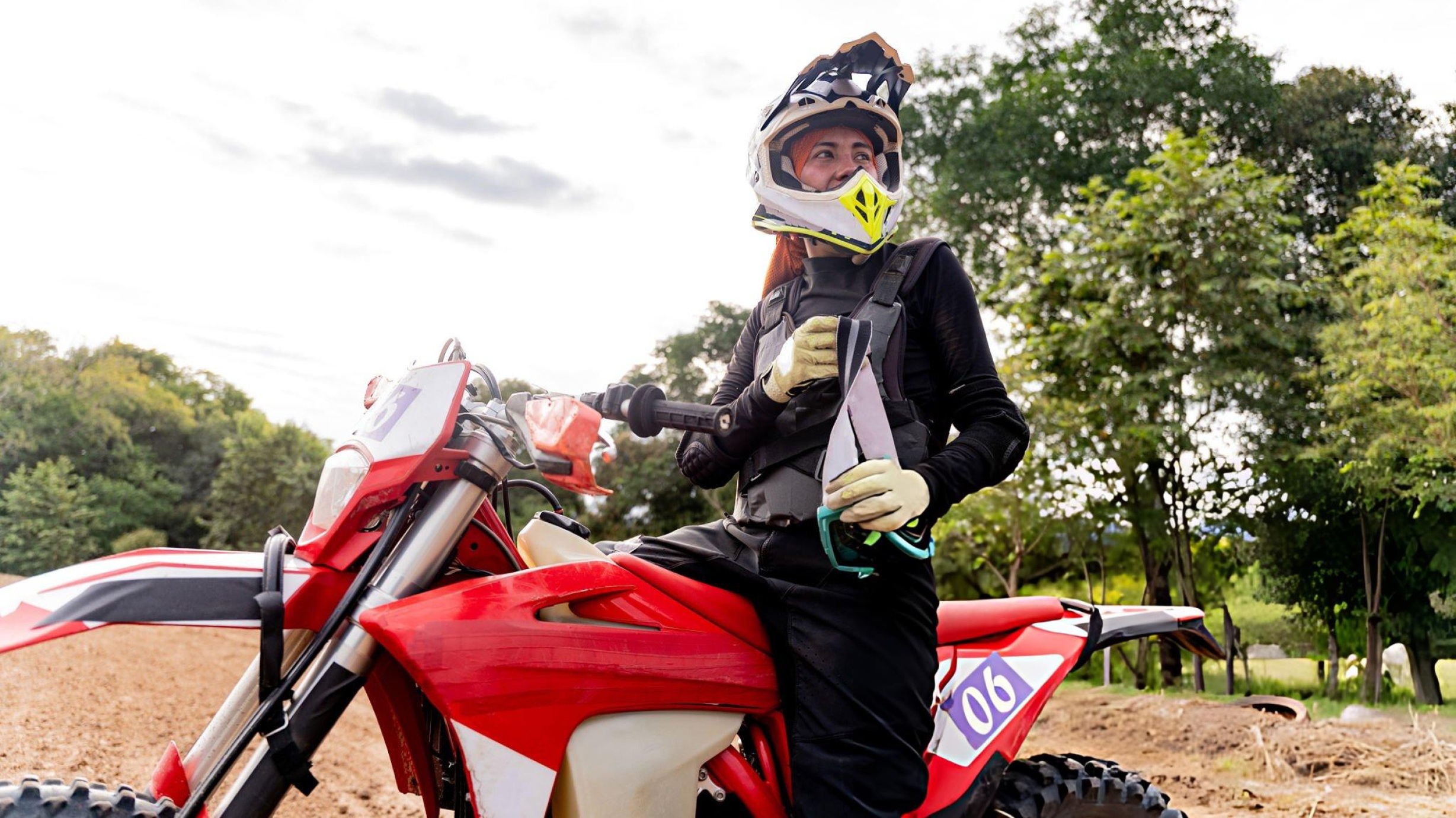Adult beginner rider on 250cc dirt bike with proper seat height on forest trail